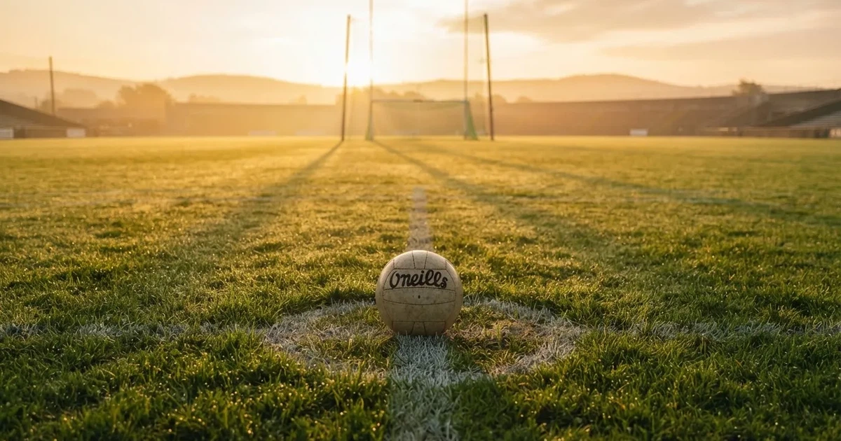A ball on the centre spot of a grass pitch in morning light