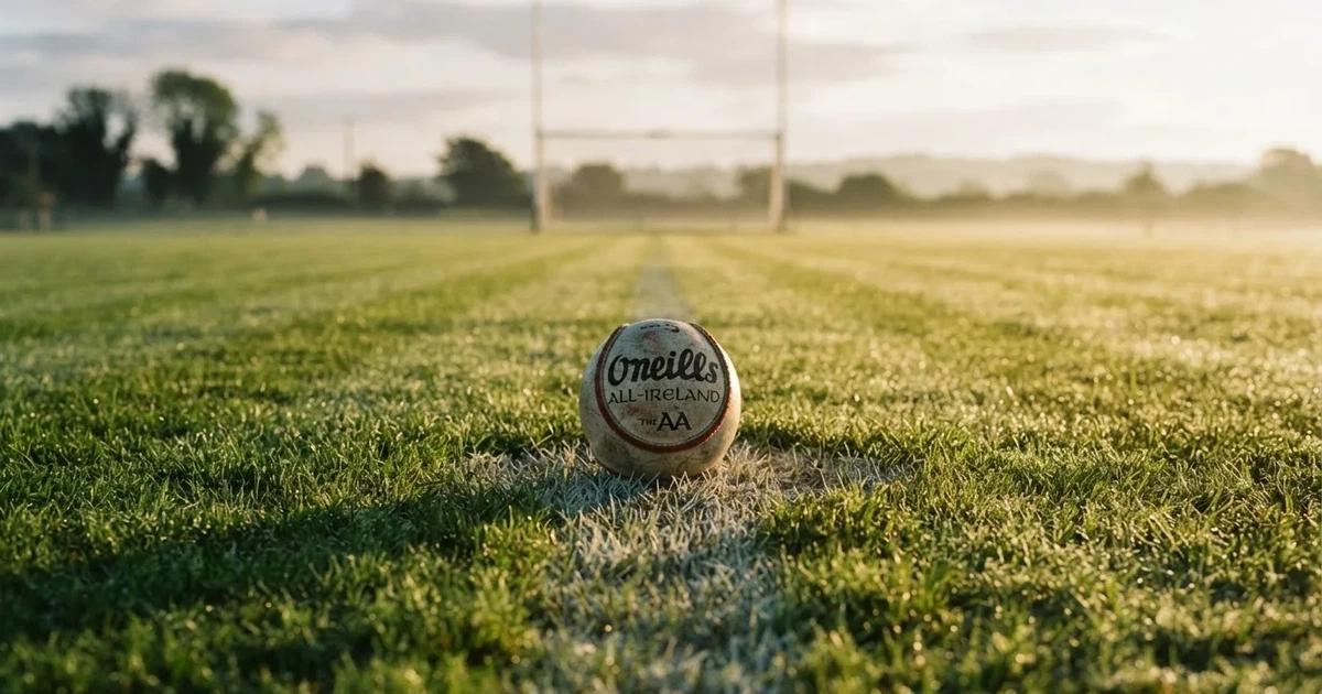 A ball on the centre spot of a grass pitch in morning light
