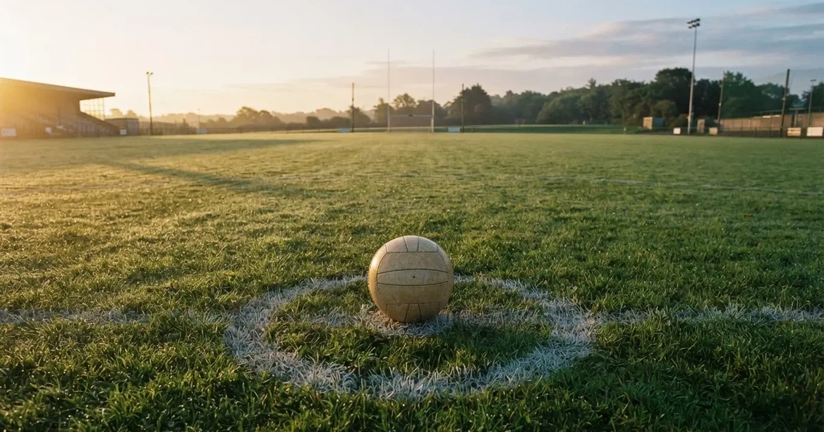 A ball on the centre spot of a grass pitch in morning light