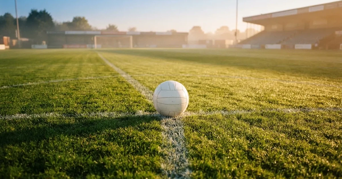 A ball on the centre spot of a grass pitch in morning light