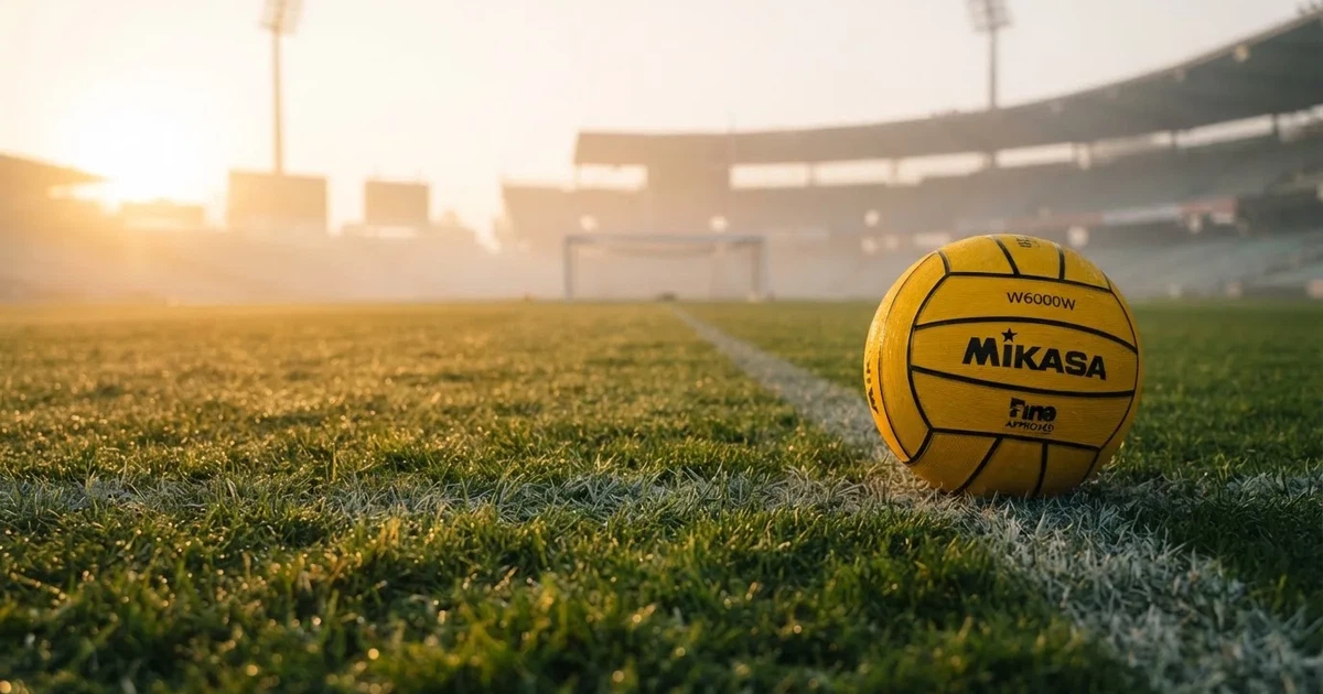 A ball on the centre spot of a grass pitch in morning light